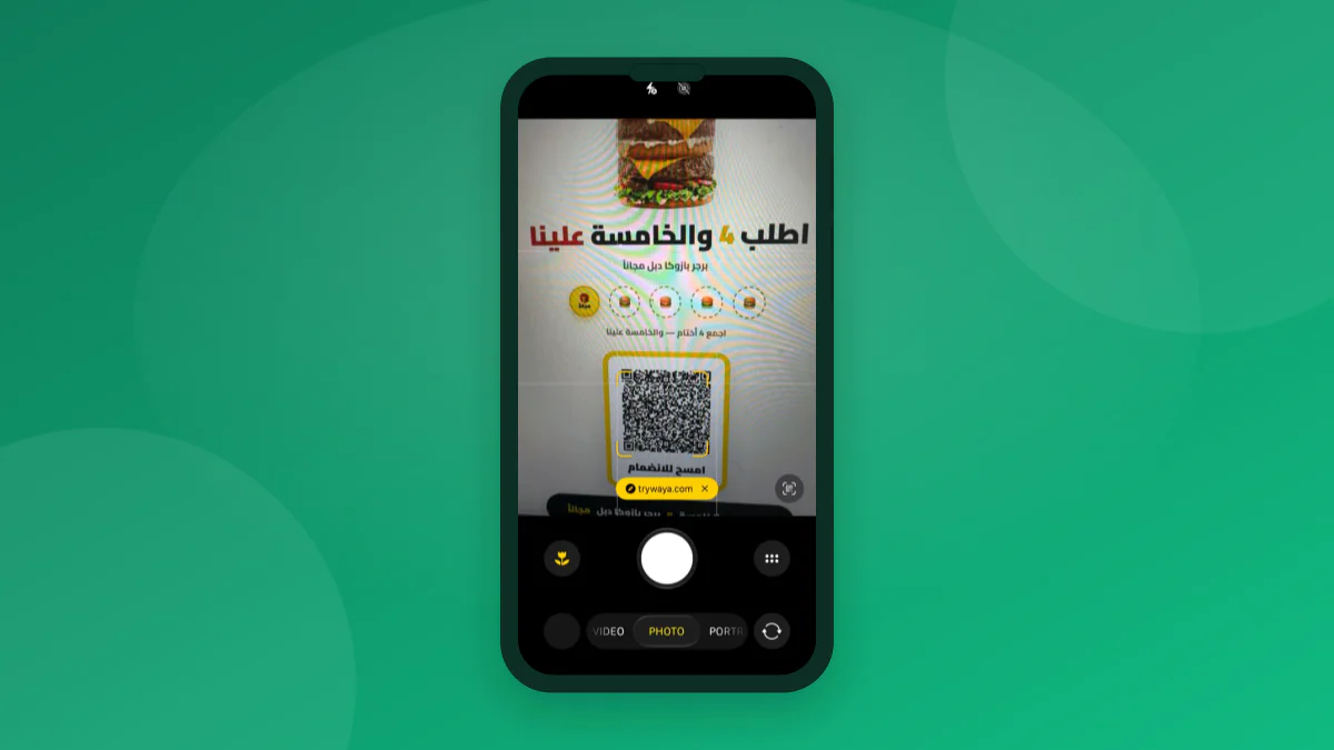 A phone camera scanning a real Waya merchant's printed QR poster for Bazooka Fried Chicken, shown inside a phone outline on an emerald background.
